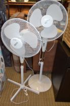 Two white finished floor standing oscillating fans