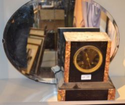 A French slate mantel clock and an oval wall mirror