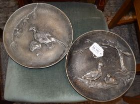 A pair of Continental cast metal wall plaques with birds in relief