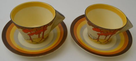 A pair of Clarice Cliff Coral Firs pattern teacups and saucers, conical cups with filled in angular