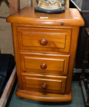 A pine three drawer bedside cupboard