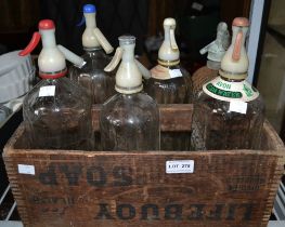 A vintage wooden crate containing six soda syphons