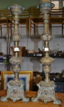 A pair of tall brass candle prickets