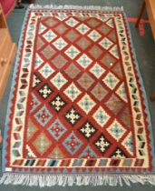 A red ground geometric patterned rug