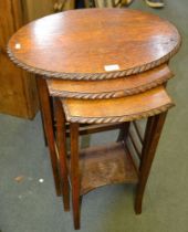 An oak nest of three tables with rope carved edge