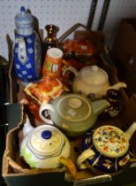A box containing a selection of tea pots and some glass wares