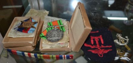 A collection of WWII medals, badges, etc.