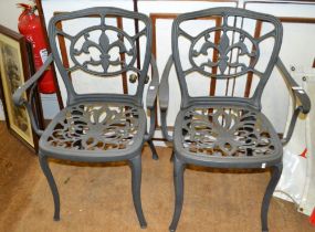 A painted green metal garden table with two chairs, together with a green painted side table