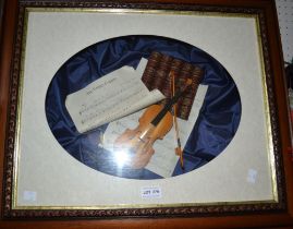 A 3-d framed miniature violin with sheet music etc