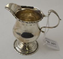 A George II silver helmet form milk jug, with gadrooned rim c scroll handle, raised on circular plat