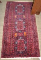 A Persian rug, three geometric shapes to centre, having stylised deer motifs, fringed & bordered, cr