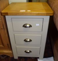 A modern light oak topped grey painted three drawer bedside cabinet