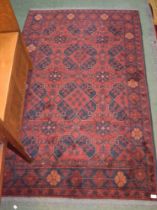 A red ground geometric patterned rug