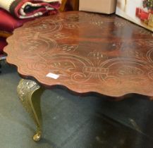 A probable middle eastern carved hard wood topped low table on four cast brass cabriole legs
