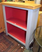 A modern light oak topped grey and red painted two shelved open cupboard