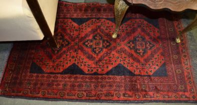 A woven woollen dark red and inky blue hearth rug