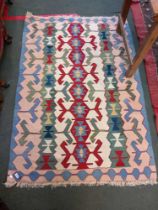 A modern multi-coloured geometric flat weave carpet