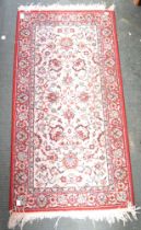 A small red ground geometric hearth rug