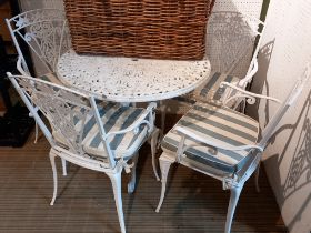 A metal circular garden table with four chairs