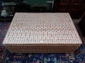 A large wicker storage unit with lift-up lid