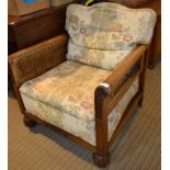 A cane panelled easy chair, floral fabric covered seat and back cushion