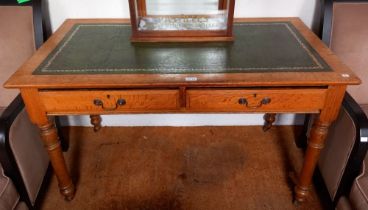 A late Victorian oak writing table, inset gilt tooled green leather top, fitted two drawers on turne