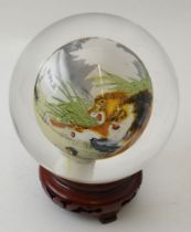 A Chinese internally painted glass ball, decorated with a pride of lions, approx 11cm diameter, rais