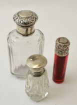 A Victorian ruby glass scent bottle with silver top, together with two other glass scent