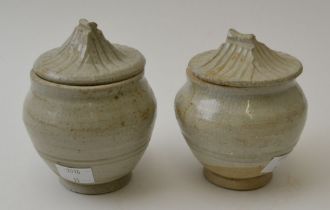 A pair of Chinese ceramic Sung style covered jars, the covers modelled in roof design, the tallest 1