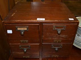 A small four drawer filing cabinet containing a large selection of vintage postcards