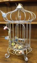 A metal decorative bird cage with contents