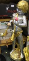 A concrete statue of Pan Piper in silver and gold