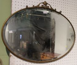 A brass framed oval bevel edged wall mirror
