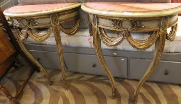 A pair of continental demi-lune wall mounted side tables with old paint and silk tops