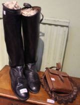 A pair of vintage leather riding boots with a cartridge belt and a leather hunting refreshment pouch