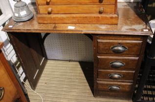A small oak child's desk with four drawers