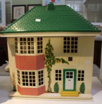A Tri-ang front sliding metal dolls house in the style of a 1930's suburban home