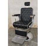 *A black and chrome hydraulic barber chair with head rest.