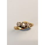 A hallmarked 9ct yellow gold three stone diamond ring of twist design, approx. total diamond