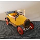 A Brum metal pedal car yellow and red.