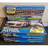 Two boxed Scalextric sets MP4-12C, Crime Patrol, and a Ultimate track extension pack.