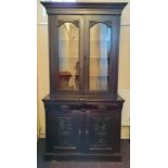 A walnut glazed bookcase with cupboard base.