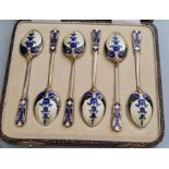 A cased set of HM silver teaspoons with blue cream and gilt enamel decoration