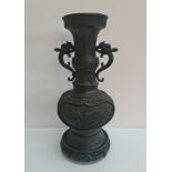 A Japanese bronze vase with bird and blossom design.