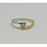 A hallmarked 18ct yellow and white gold diamond solitaire ring, set with a princess cut diamond,