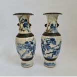 A pair of Chinese crackle glazed blue and white vases with warriors fighting scenes height 30,5.