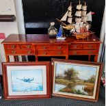 A mahogany hall table with nine drawers two framed pictures and five models of boats.