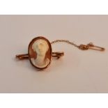 A yellow metal framed cameo brooch with safety chain.