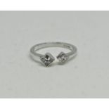 A hallmarked 18ct white gold two stone diamond ring, set with a princess cut diamond measuring