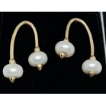 A pair of hallmarked 9ct yellow gold pearl earrings, each set with two white button pearls connected